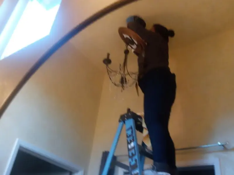 Electrician installing a chandelier in a Toppenish residence